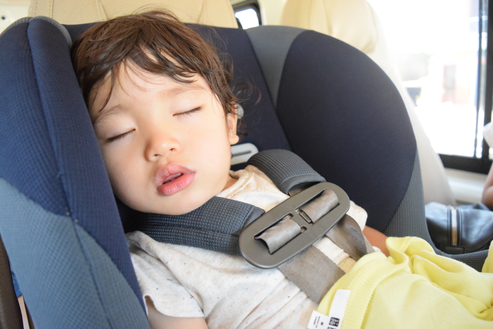 車で寝ている子供