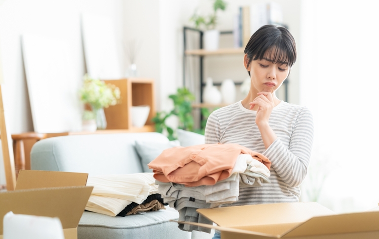 女性が洋服の片づけ中