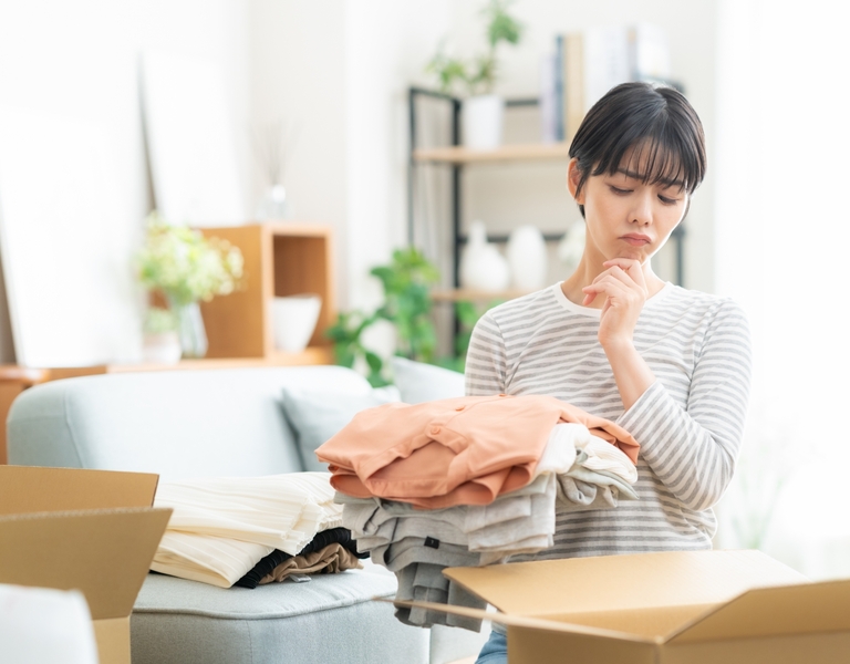 女性が洋服の片づけ中