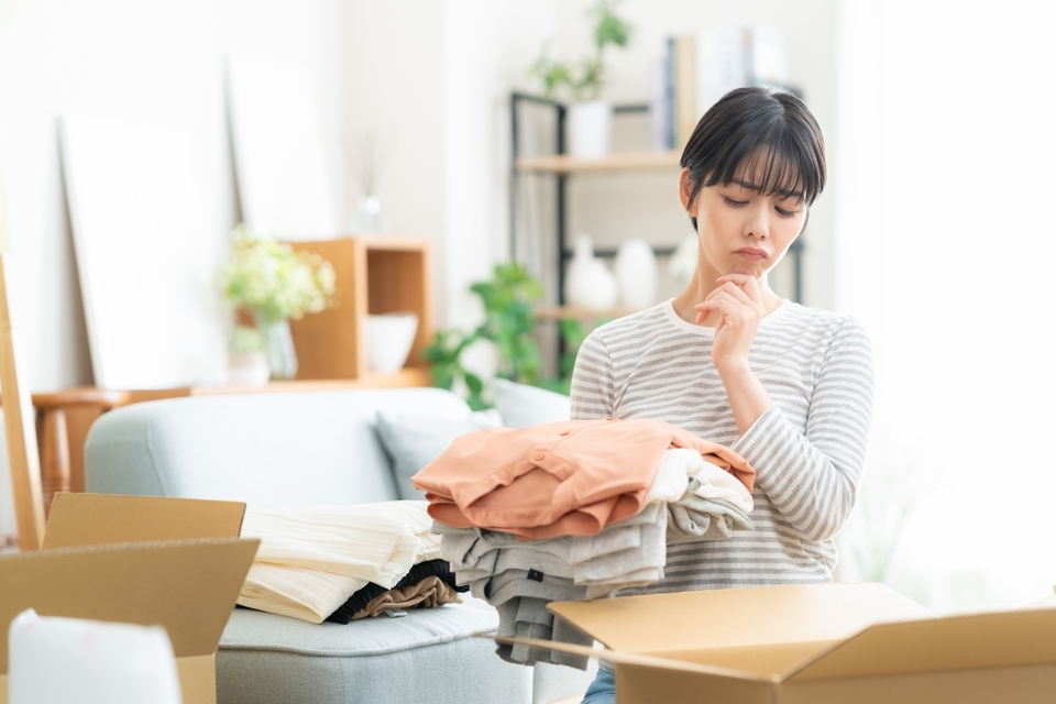 女性が洋服の片づけ中