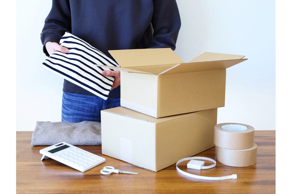 洋服を郵送パックに入れる様子